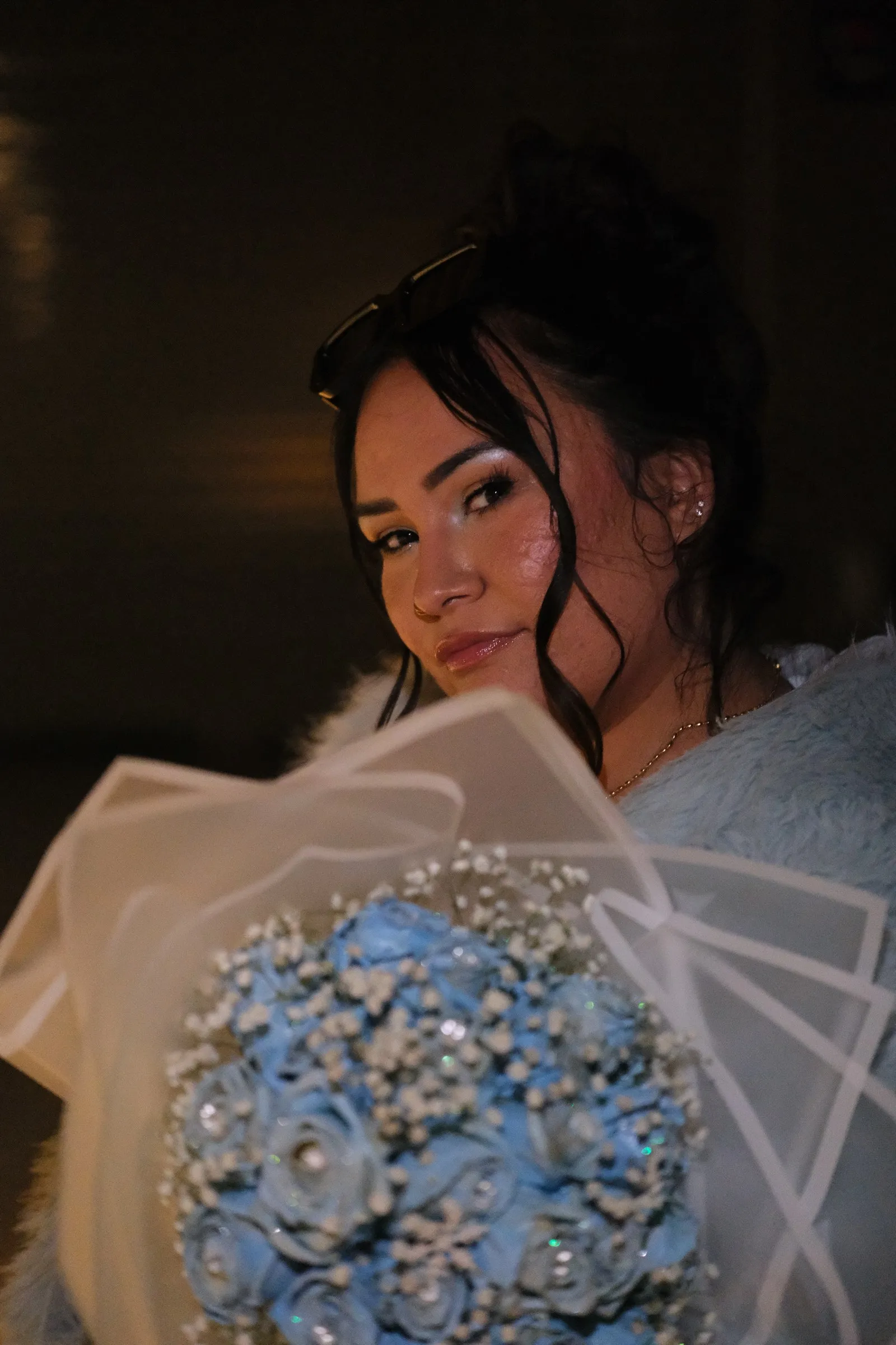 Amanda holding a bouquet, photographed at night on her 28th birthday.