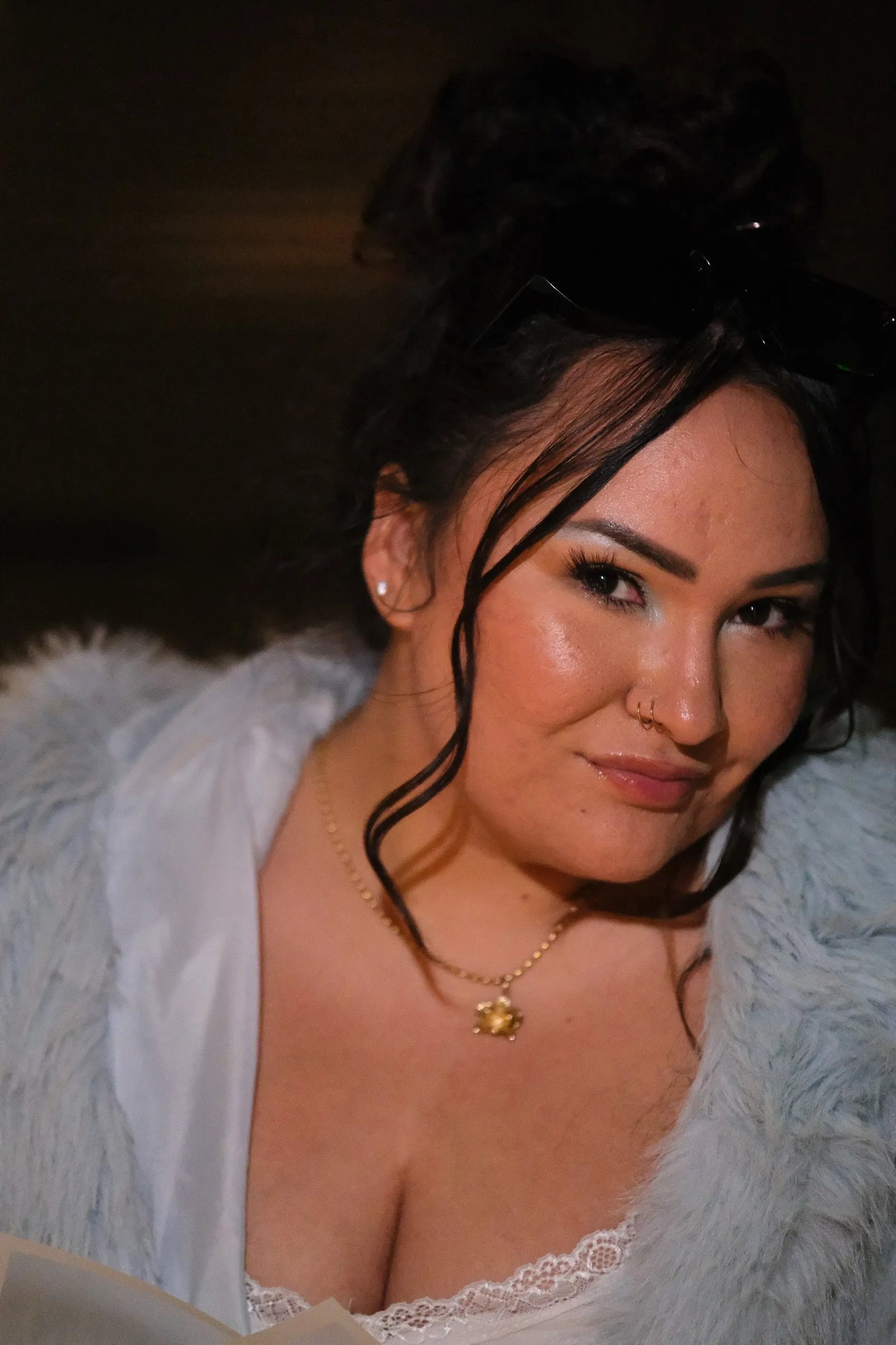 Amanda in a pale blue coat and gold pendant, photographed at night on her 28th birthday.